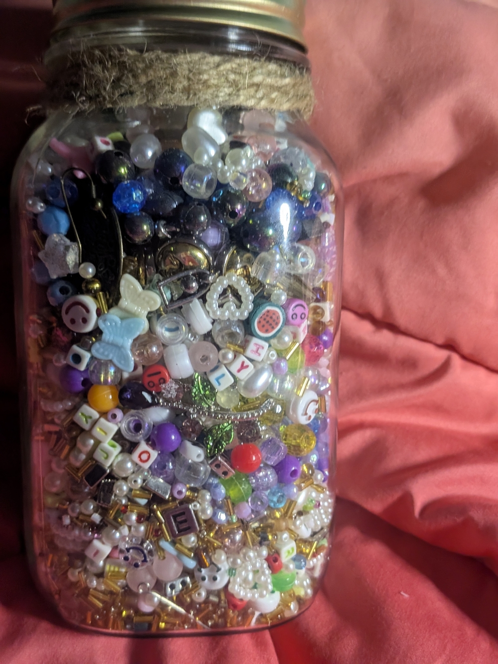Mason Jar Filled with Colorful Craft Beads and Charms